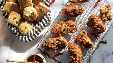 fried chicken on a wire rack and biscuits in a bowl.
