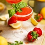 strawberry lemon drop martini on a serving board with fresh lemons and strawberries.