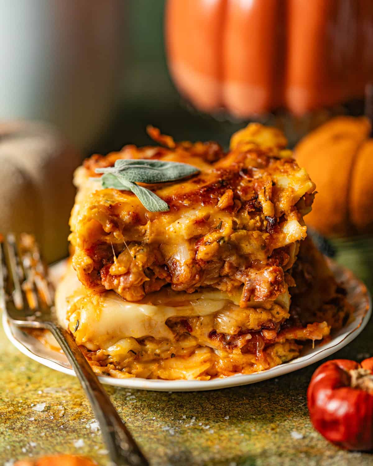 slices of pumpkin lasagna stacked on top of each other on a small plate with a fork.