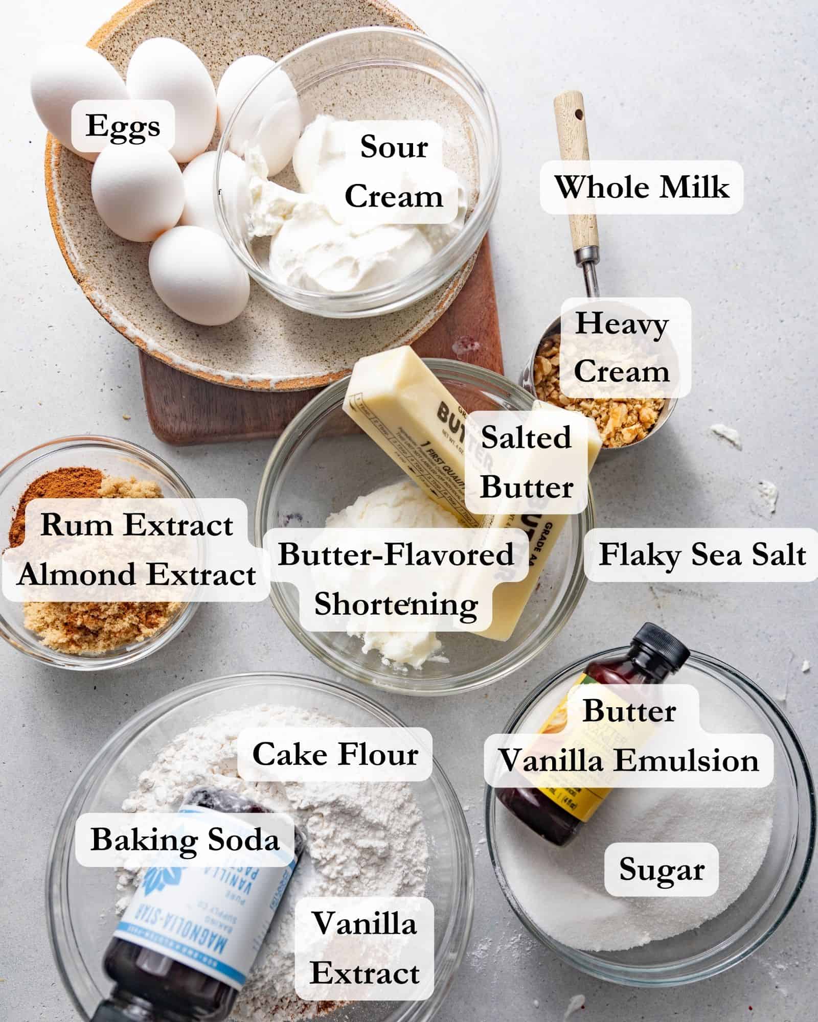 salted caramel kentucky butter cake ingredients - cake flour, sugar, eggs, shortening, rum extract, butter emulsion, heavy cream, almond extract, vanilla extract, butter, sour cream, and milk.