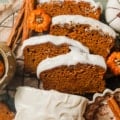 pumpkin bread with cream cheese frosting sliced with tiny pumpkins next to it