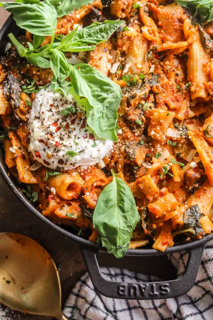 pasta in a tomato sauce covered with basil and burrata