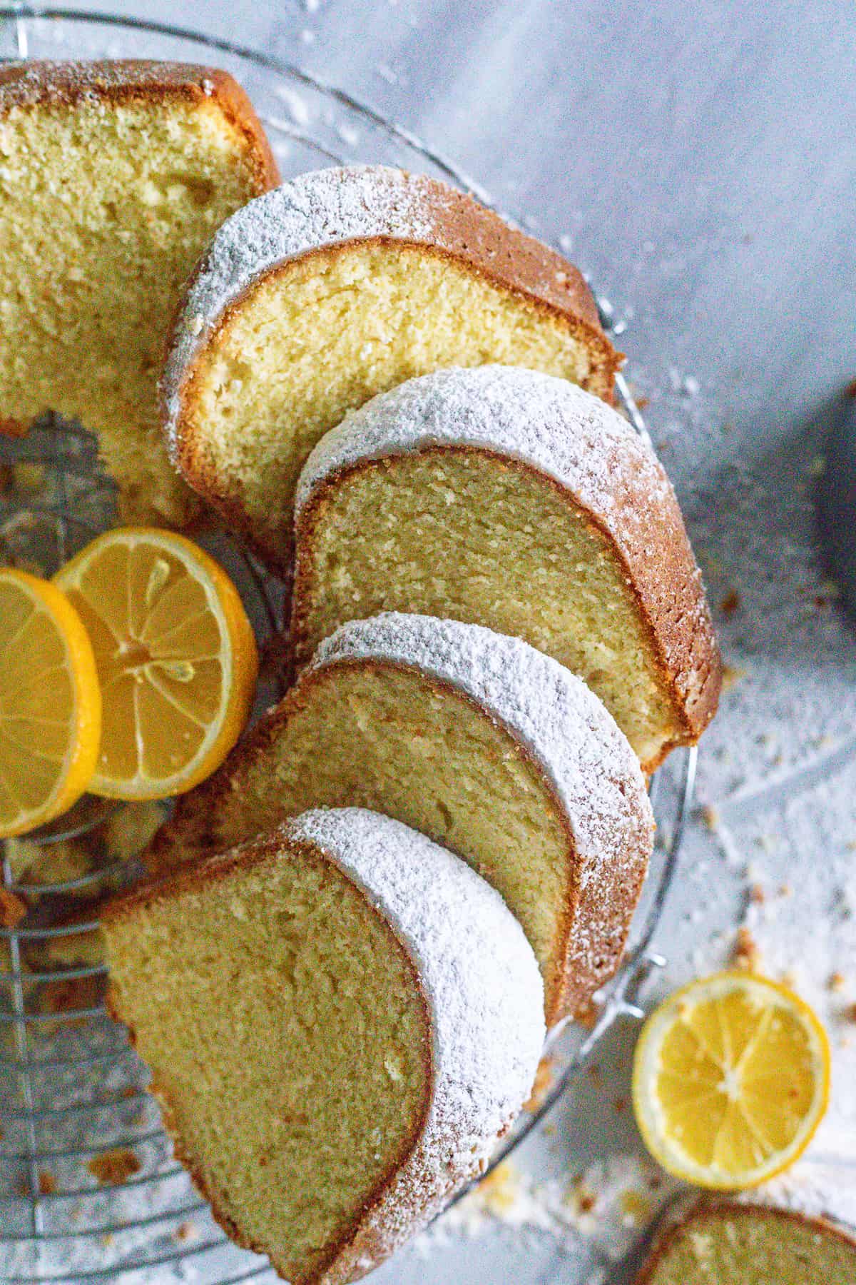Sour Cream Pound Cake sliced on a wire rack and garnished with lemons.