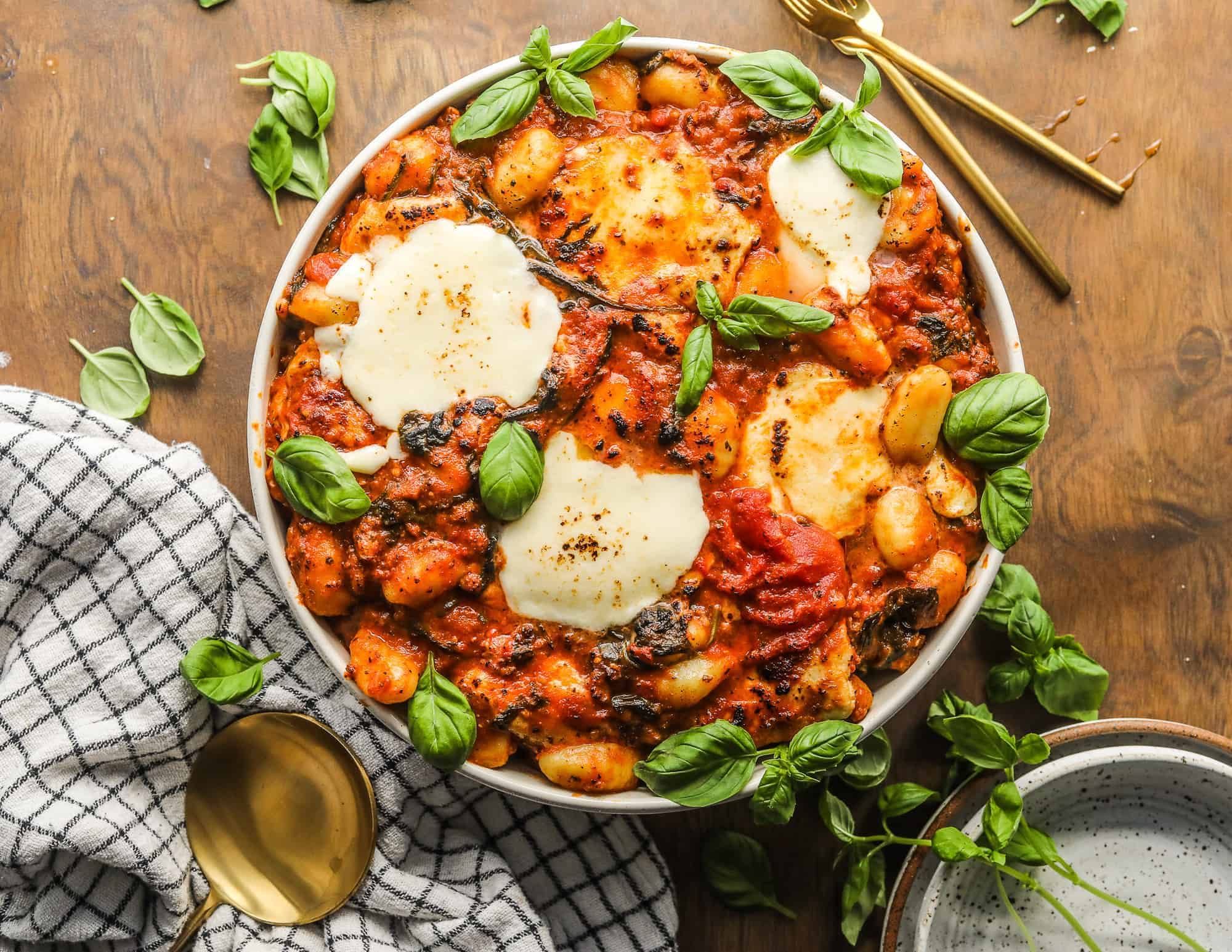 Sausage and Spinach Gnocchi Bake in a bowl garnished with basil