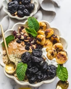 caramelized bananas and prunes with nut butter dried fruit on top of oatmeal