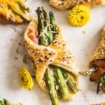 Asparagus and Prosciutto Puff Pastry Bundles on a piece of parchment paper