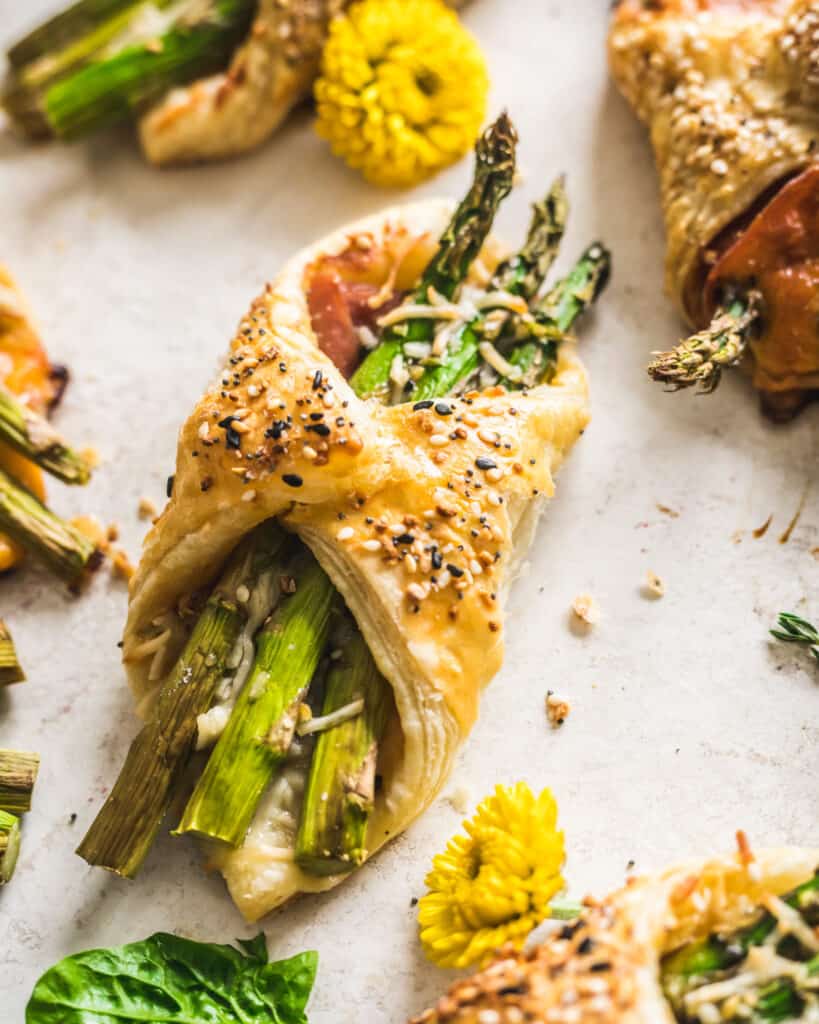 Asparagus and Prosciutto Puff Pastry Bundles on a piece of parchment paper