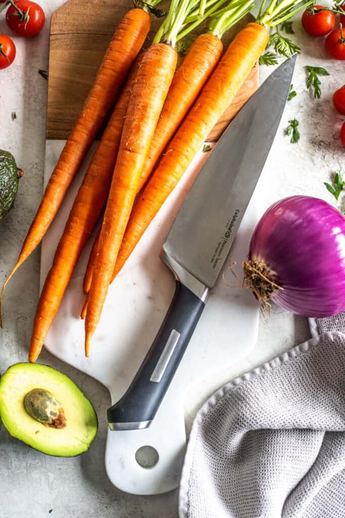 Julienne carrots on cutting board with a knife