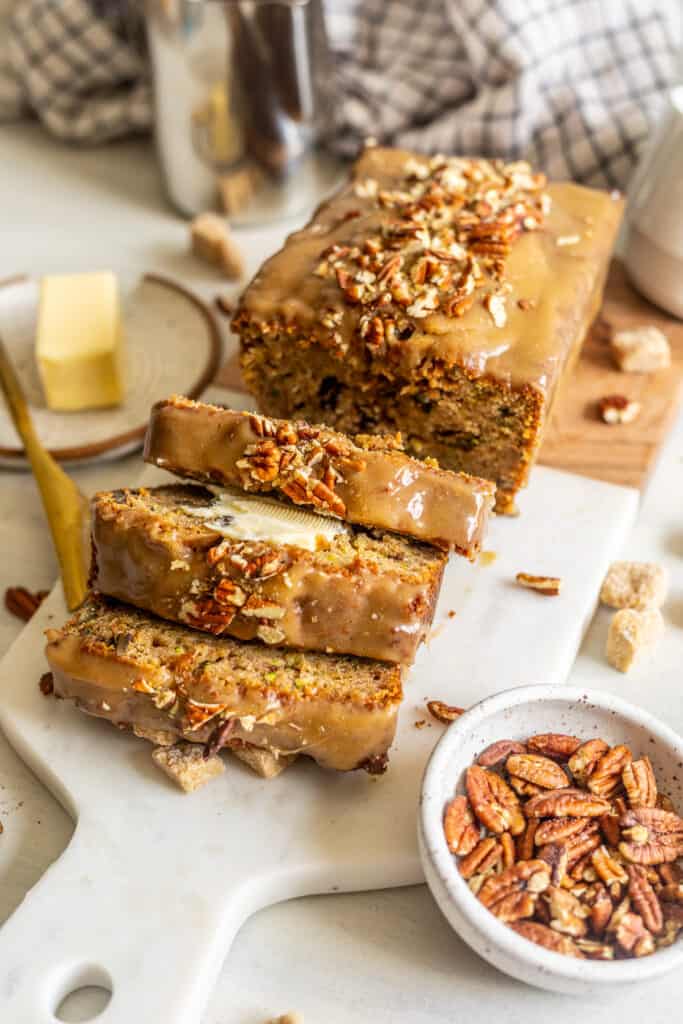 Zucchini Bread with Maple Glaze on a table with pecans