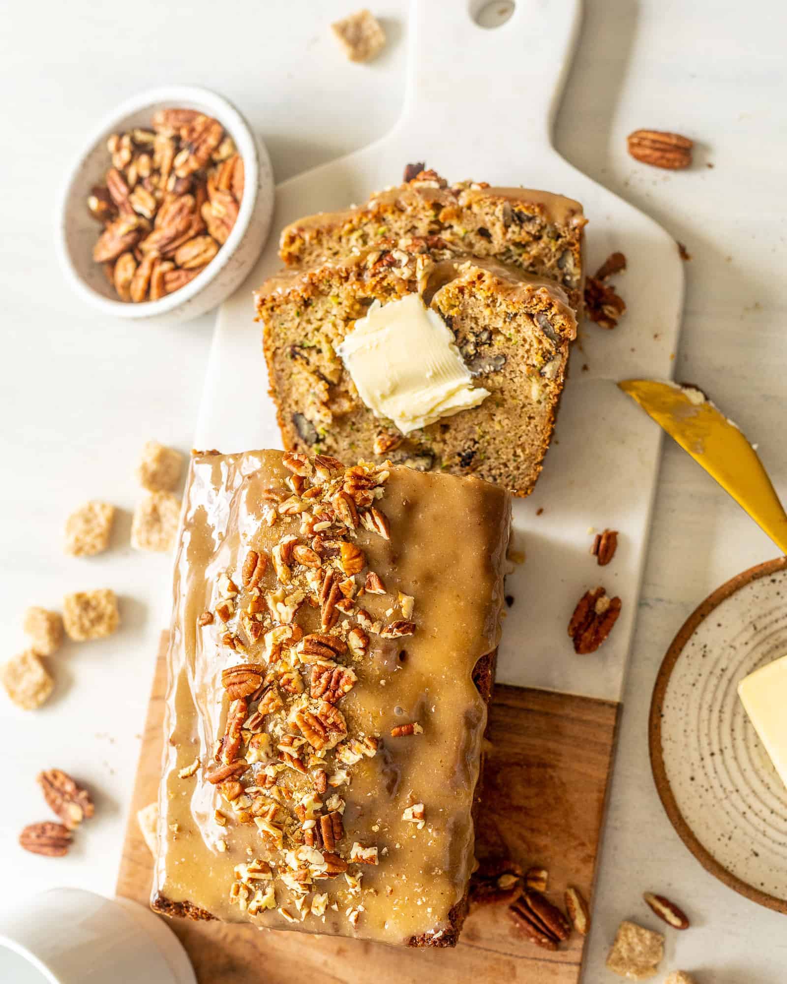 Zucchini Bread with Maple Glaze on a table with pecans
