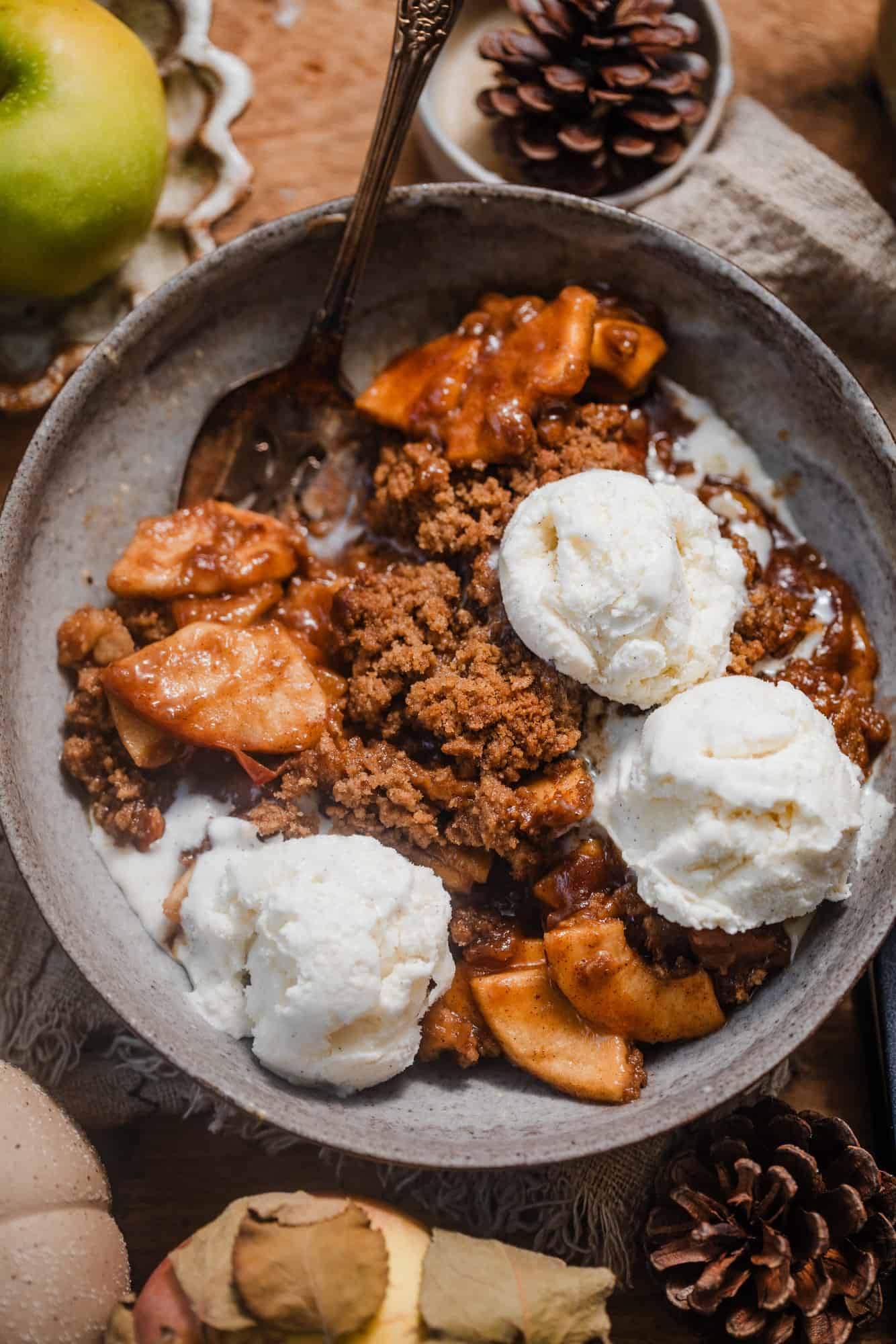 apple crisp without oats in a bowl showing the crisp crumble topping with juicy apples underneath. 