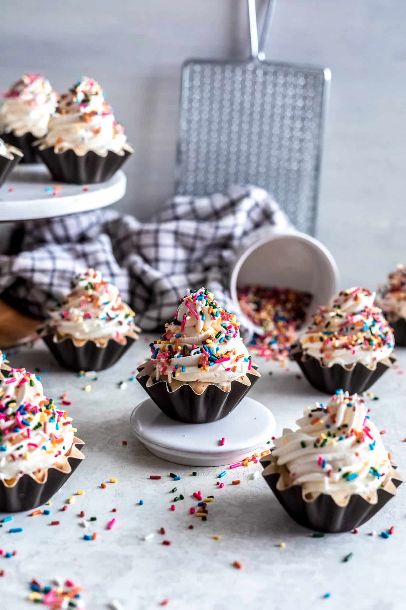 Cupcakes with sprinkles on top on a white surface