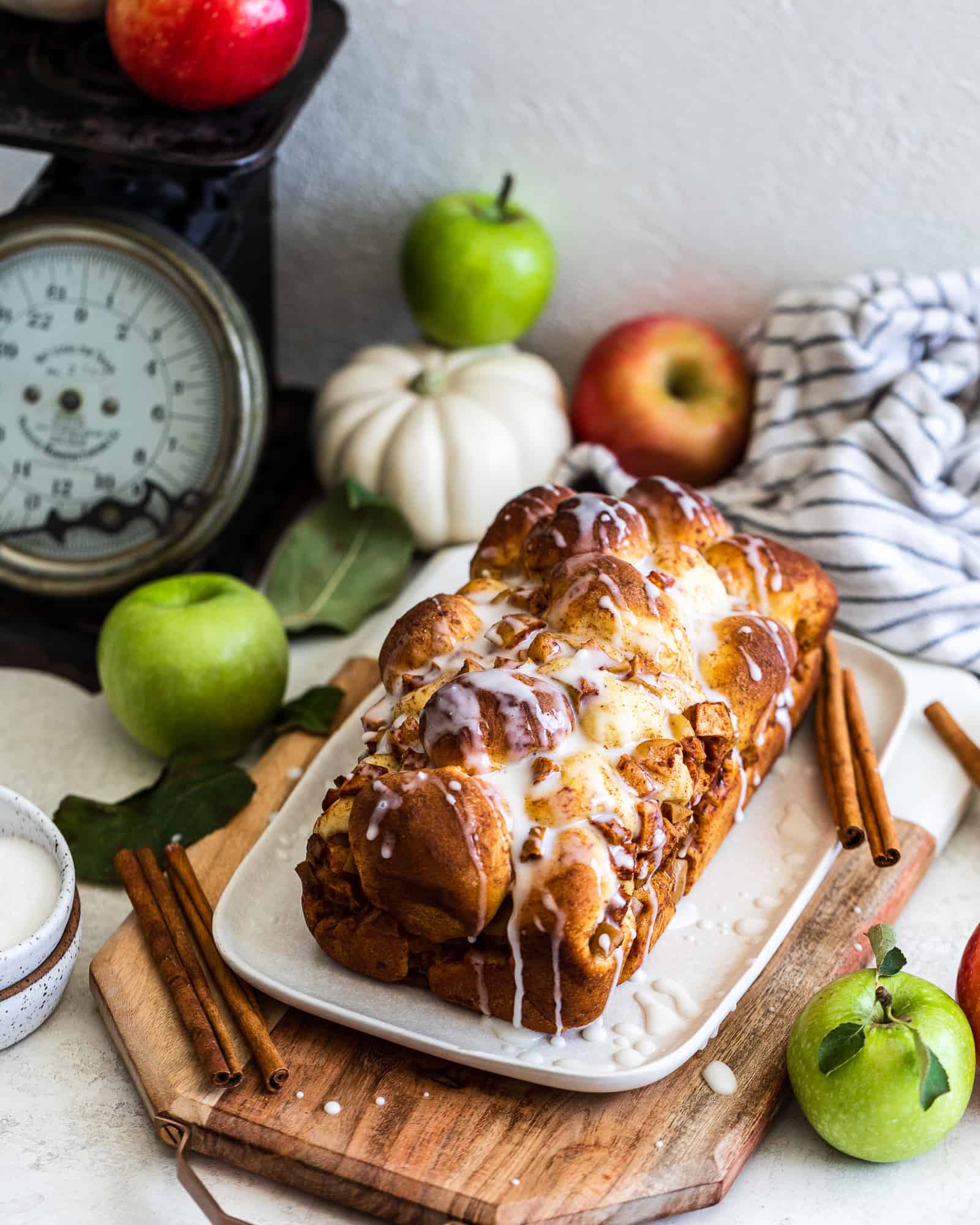 Apple and Pear Bread with apples and a pumpkin behind it