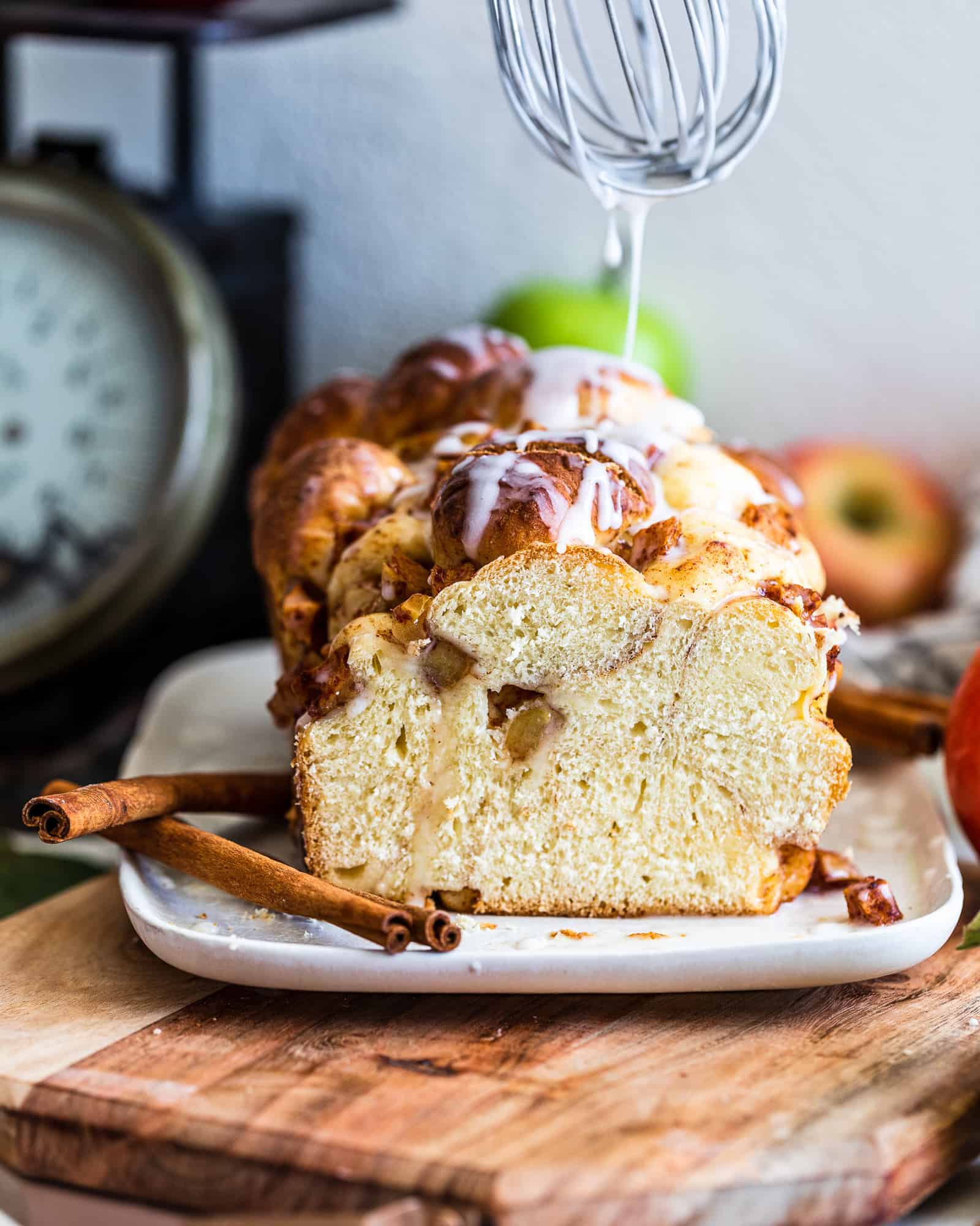 Apple and Pear Bread with whisk drizzling glaze on top