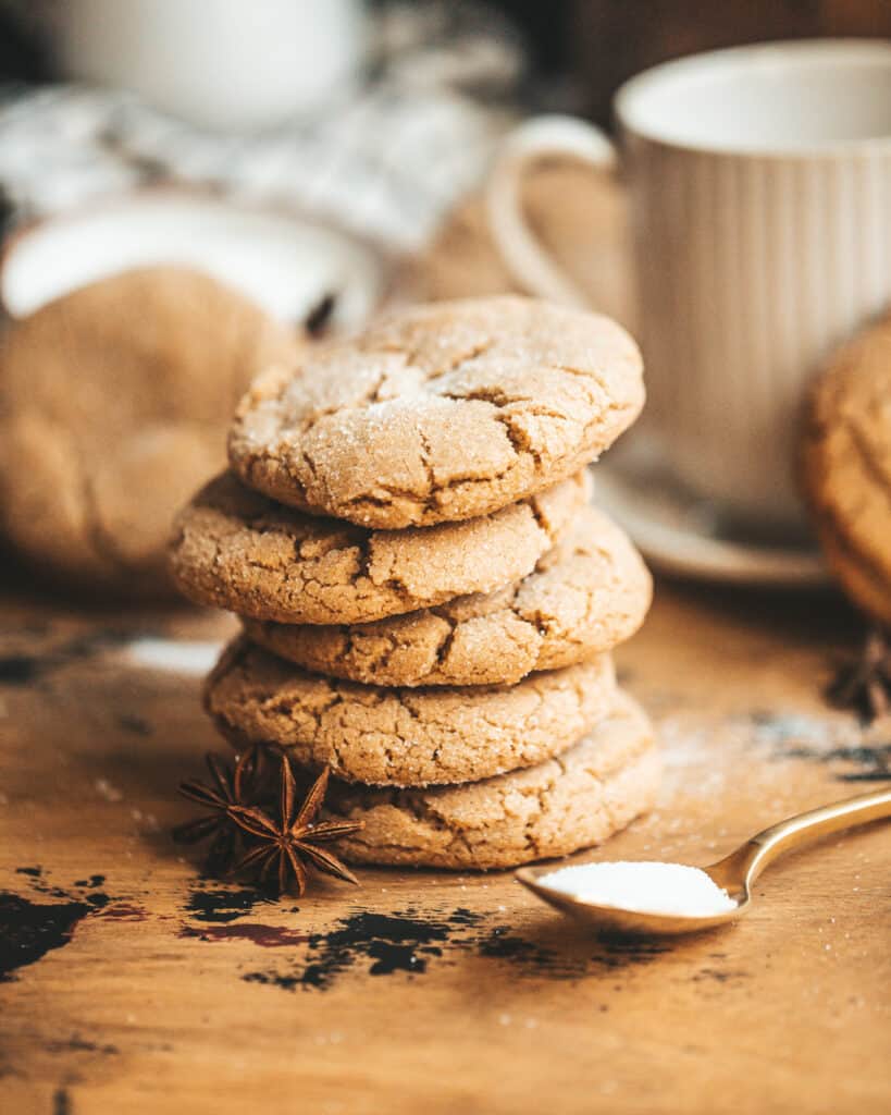 brown butter chai Cookies stacked on top of each other with a mug in the background