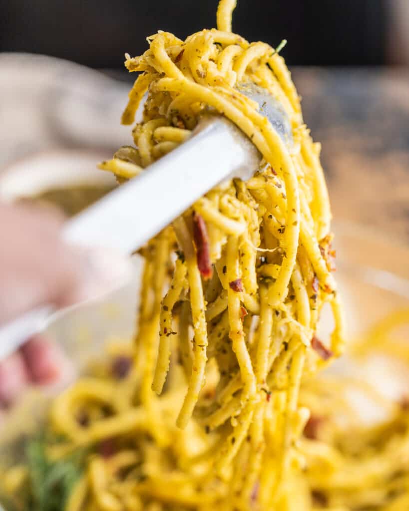 tongs holding up pasta 