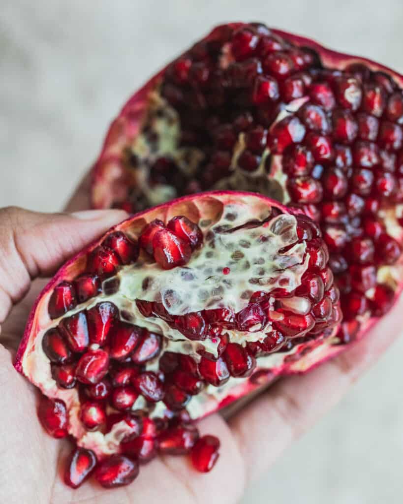 A pomegranate cut in half revealing pomegranate seeds