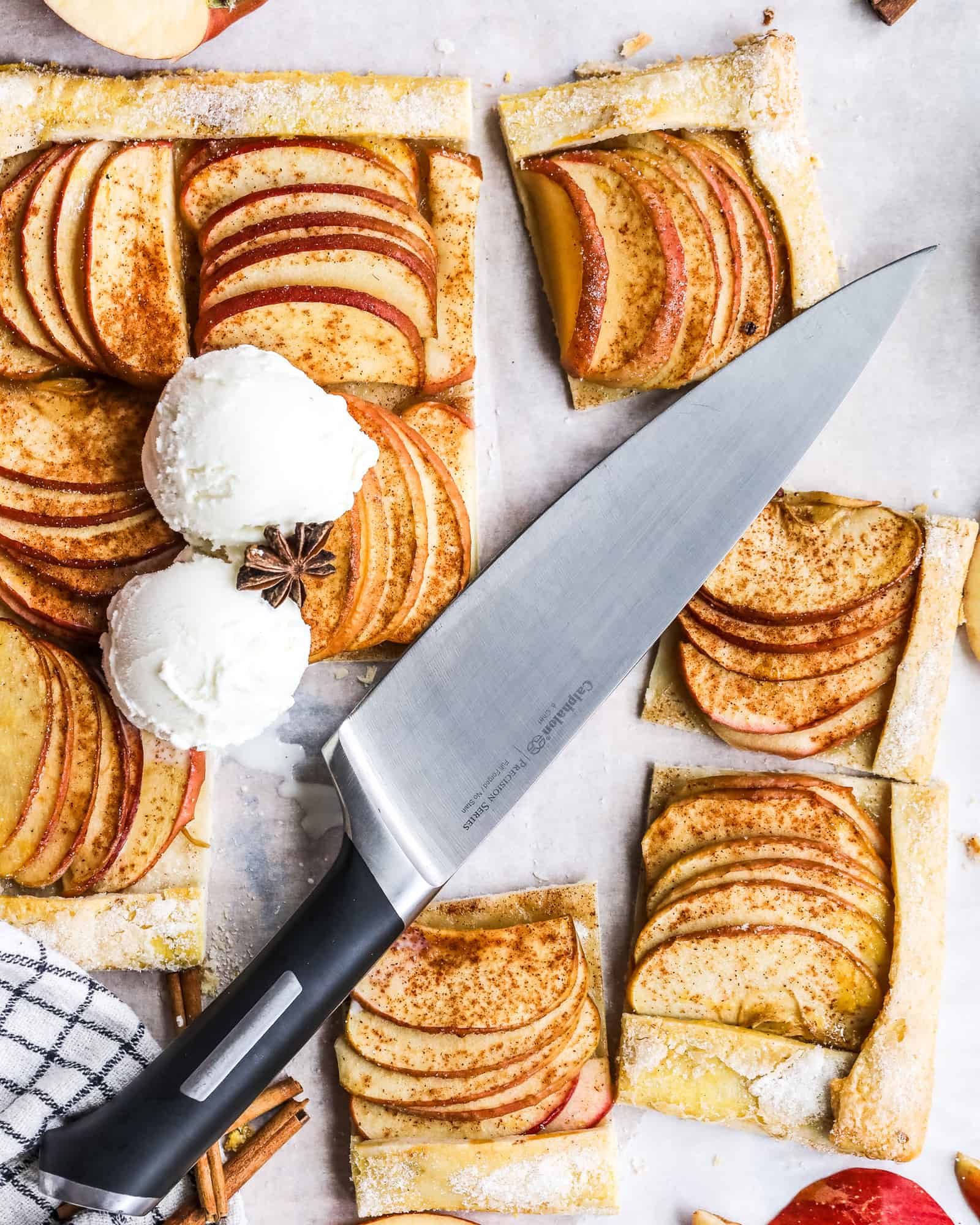 cinnamon sugar apple galette cut into squares with a calphalon knife on top