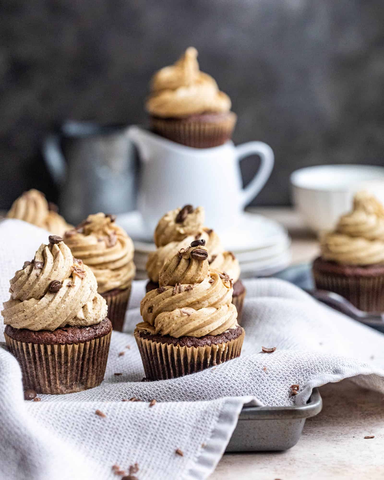 chocolate cupcakes with espresso buttercream in a baking sheet with a dish cloth