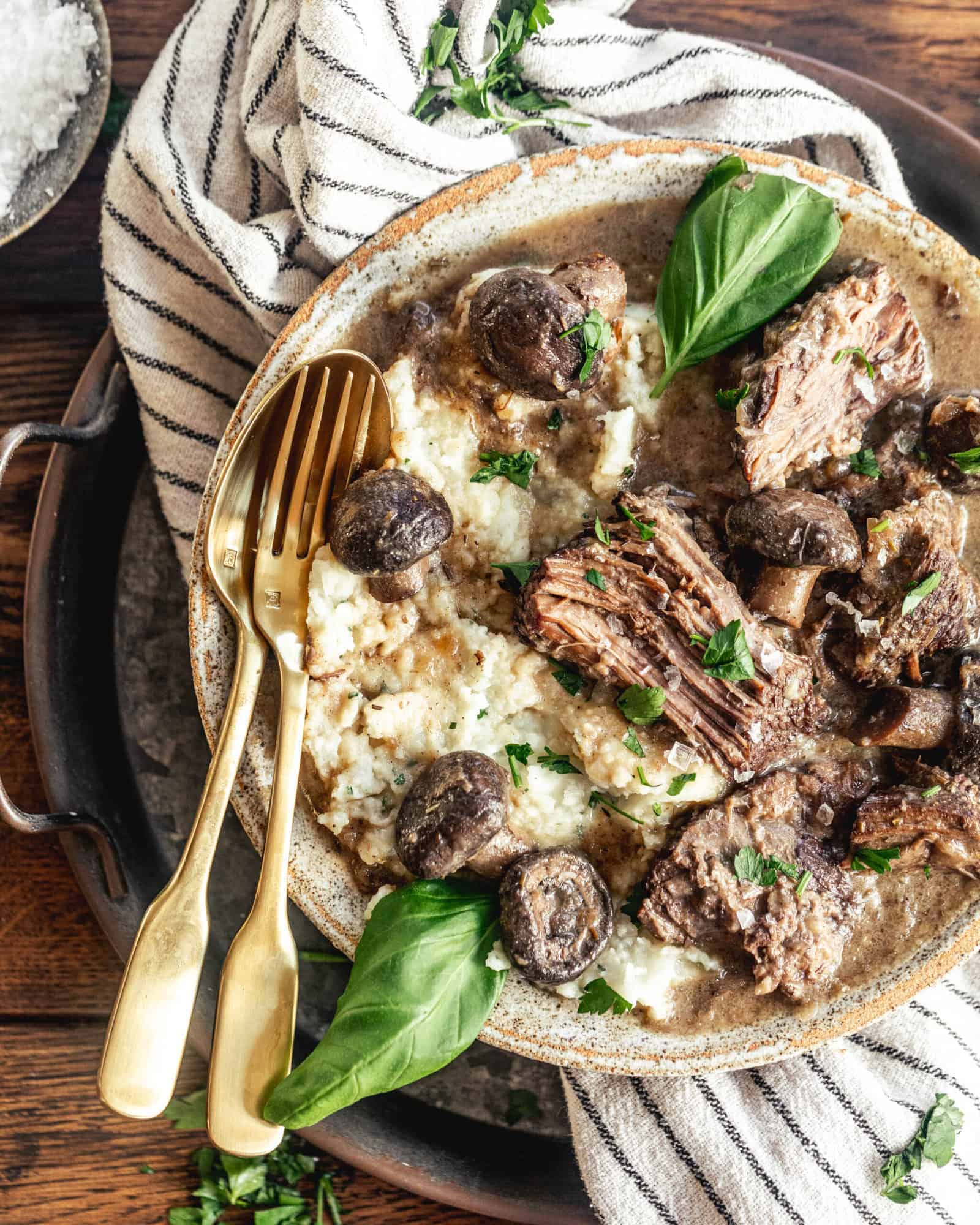 creamy dijon braised beef in a bowl with a fork and spoon