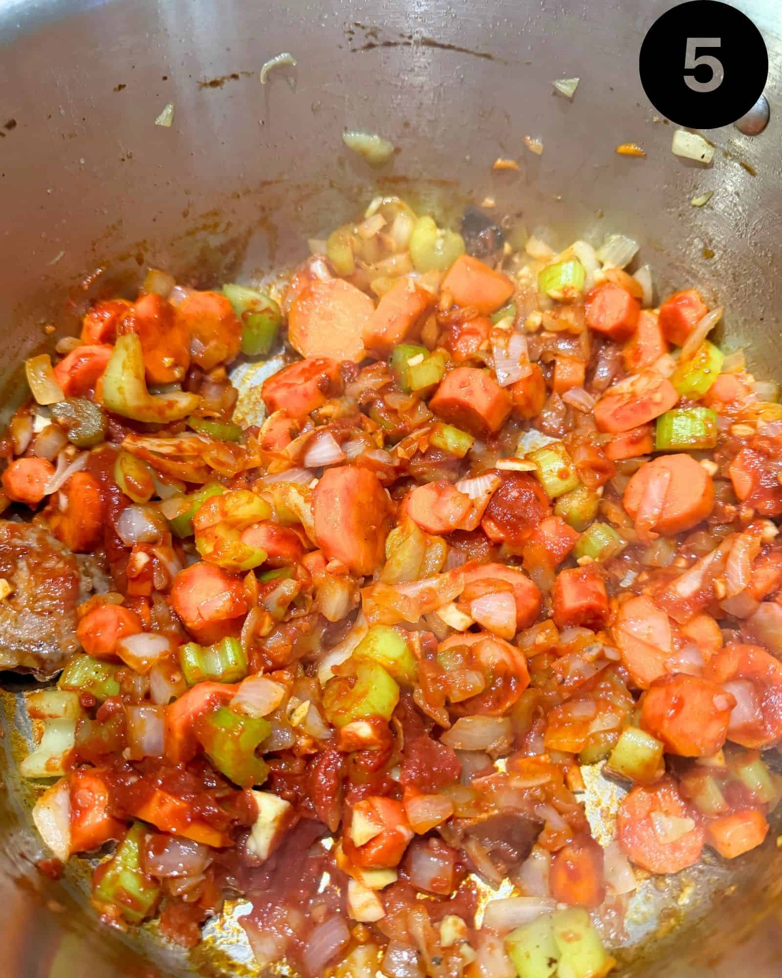 celery, carrots, onion, and garlic in a pot with crushed tomatoes and tomato paste.