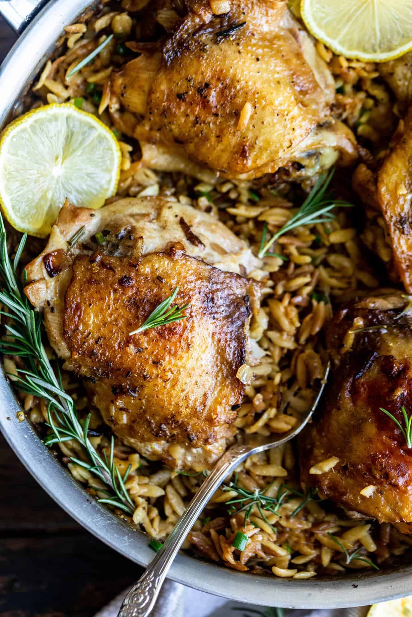 chicken and orzo in a pan with rosemary and lemon