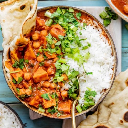 Sweet Potato Chickpea Curry in a bowl with garlic naan