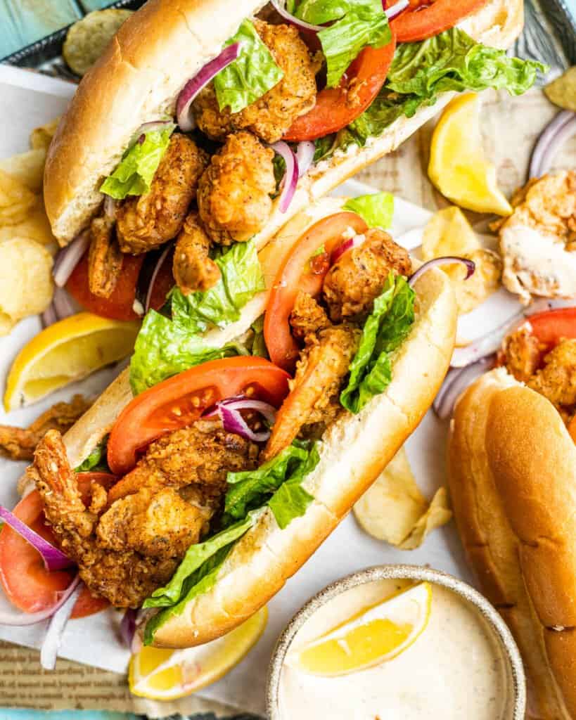 shrimp po'boy on a serving tray with sauce