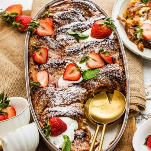 strawberry french toast casserole in a baking dish with strawberries and mascarpone