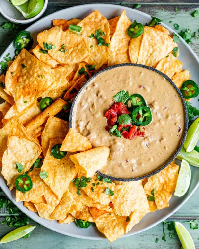 chunky vegan queso in a bowl with tortilla chips