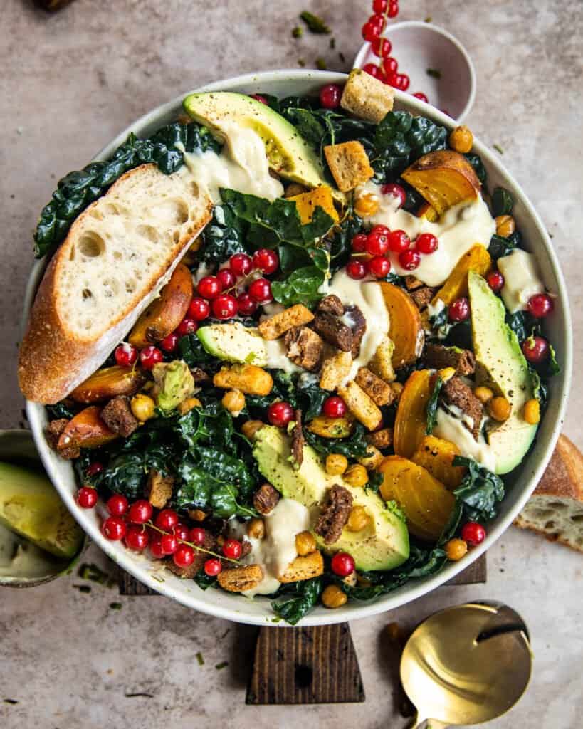 vegan kale caesar salad in a bowl with bread