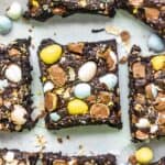 mini egg brownies cut into squares on a white surface