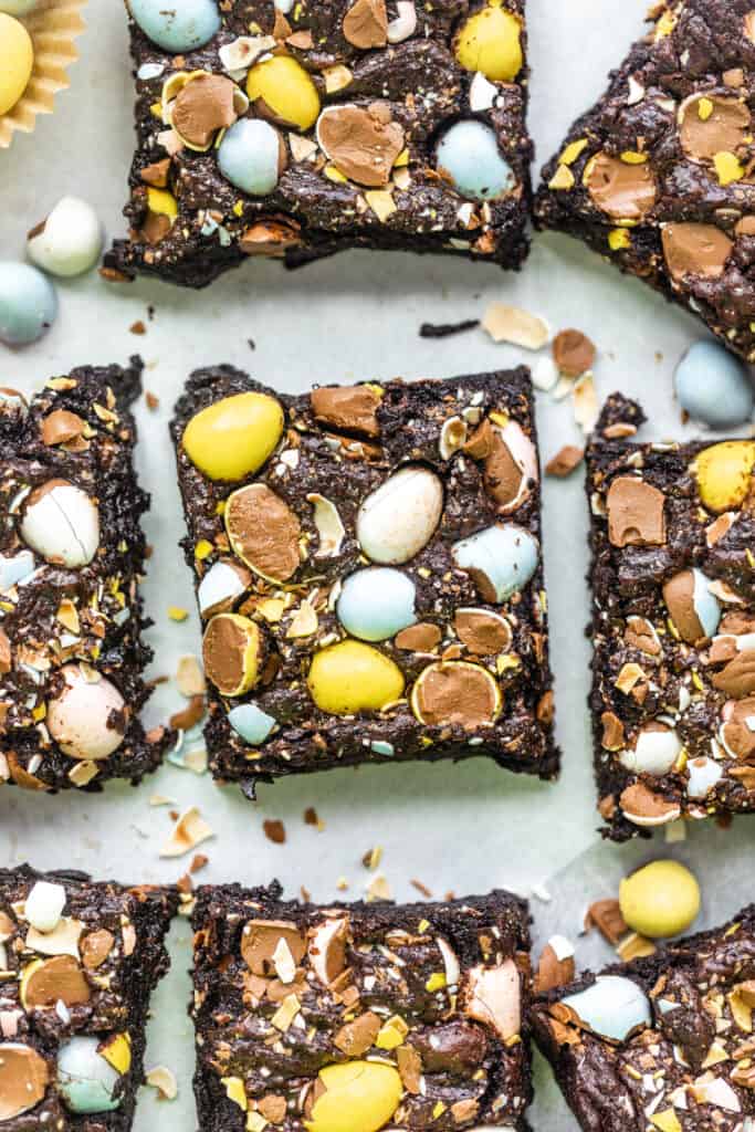 mini egg brownies cut into squares on a white surface