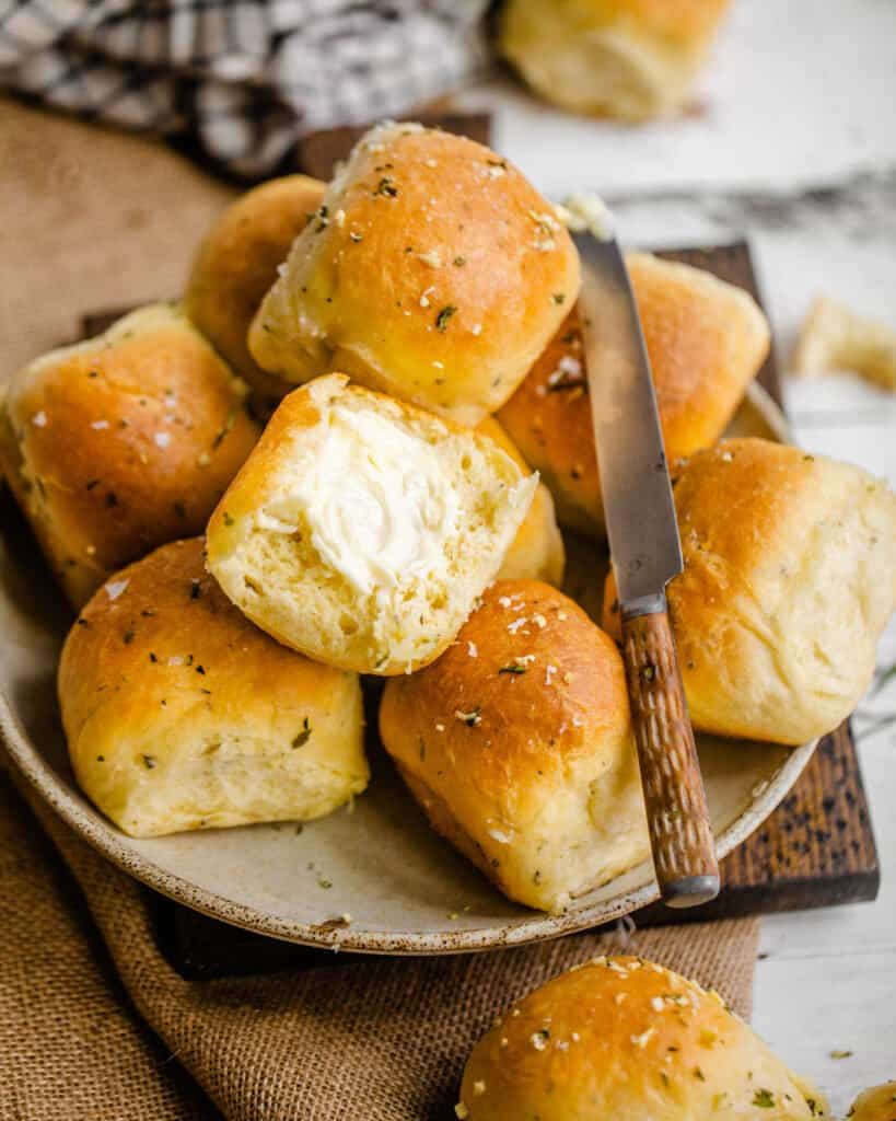 baked rolls on a plate with a butter knife