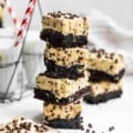 cookie dough brownies stacked on top of each other with a glass of milk