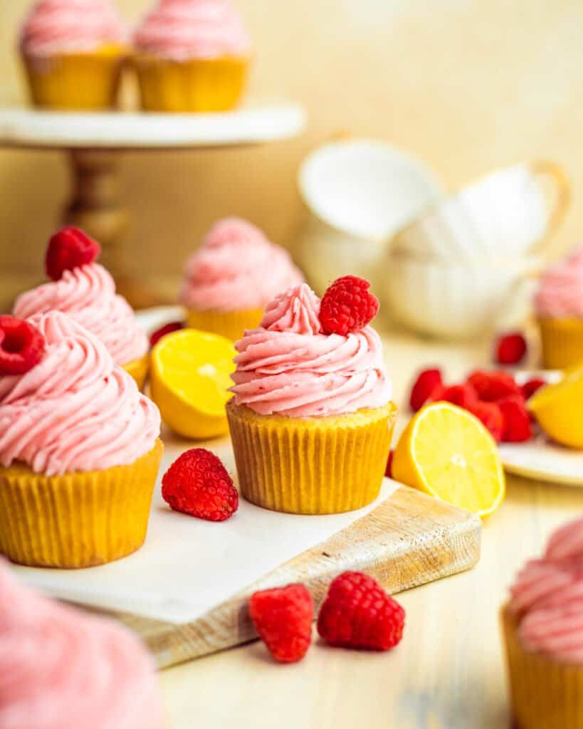 lemon cupcakes with raspberry buttercream topped with a raspberry