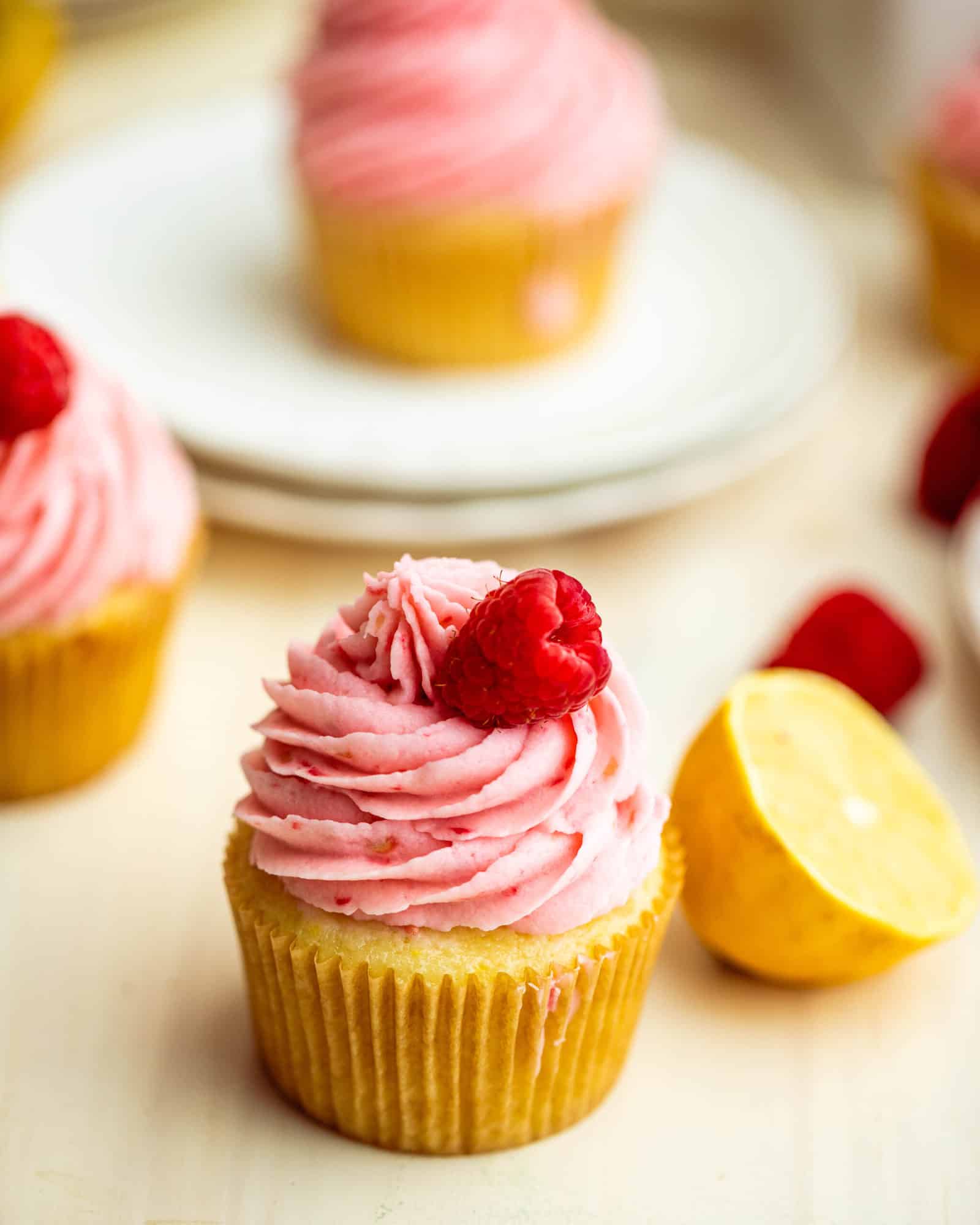 a lemon raspberry cupcake next to a lemon