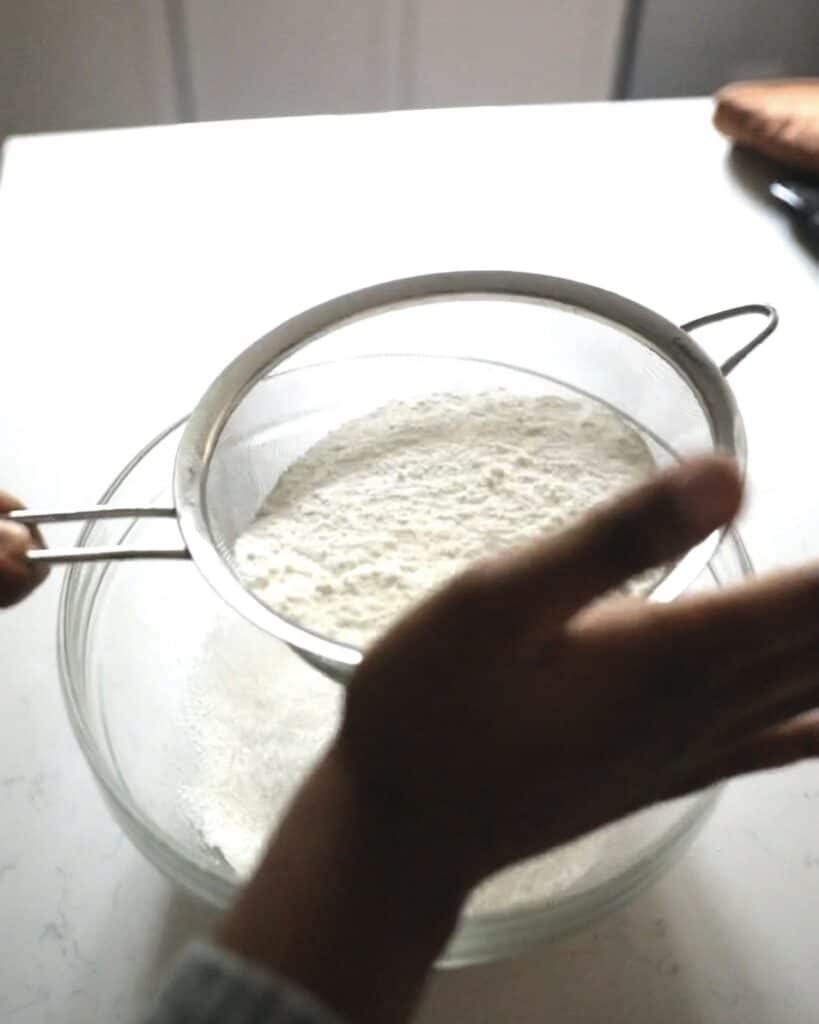 sifting almond flour and powdered sugar