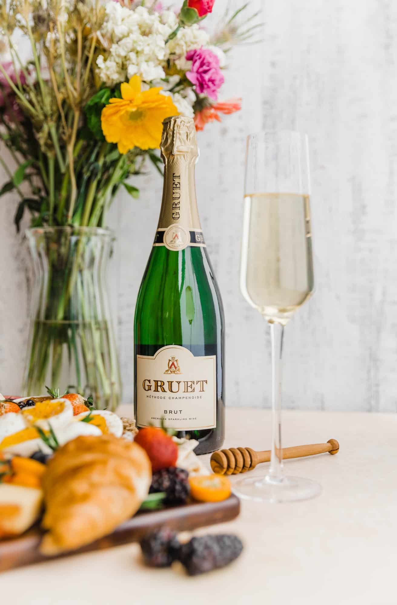 a bottle of champagne under a bouquet of flowers with a champagne flute