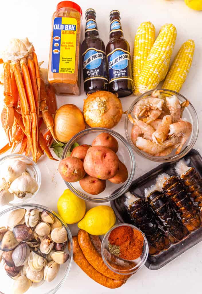 ingredients to make a cajun seafood boil on a white surface