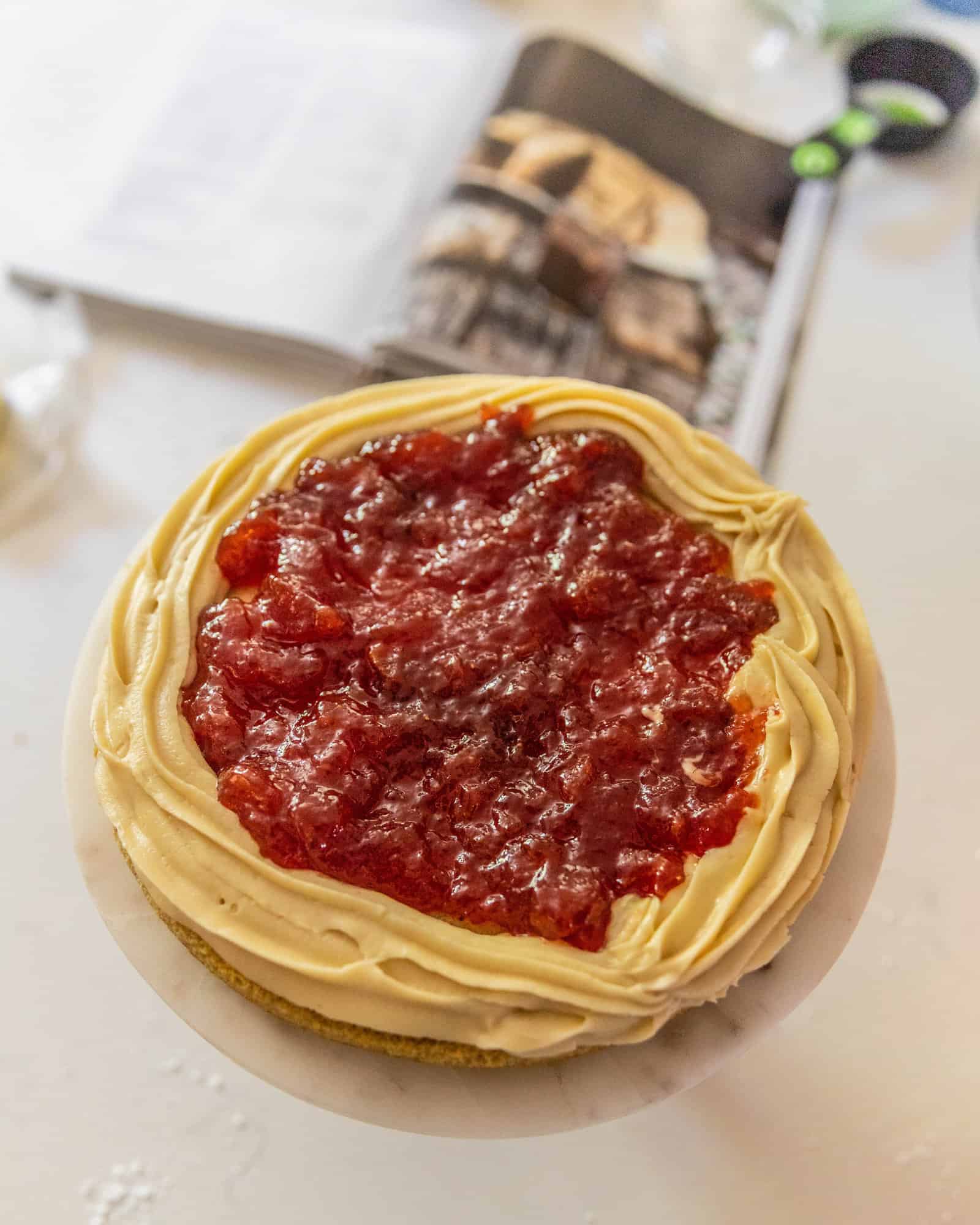 layer cake with icing and strawberry jam