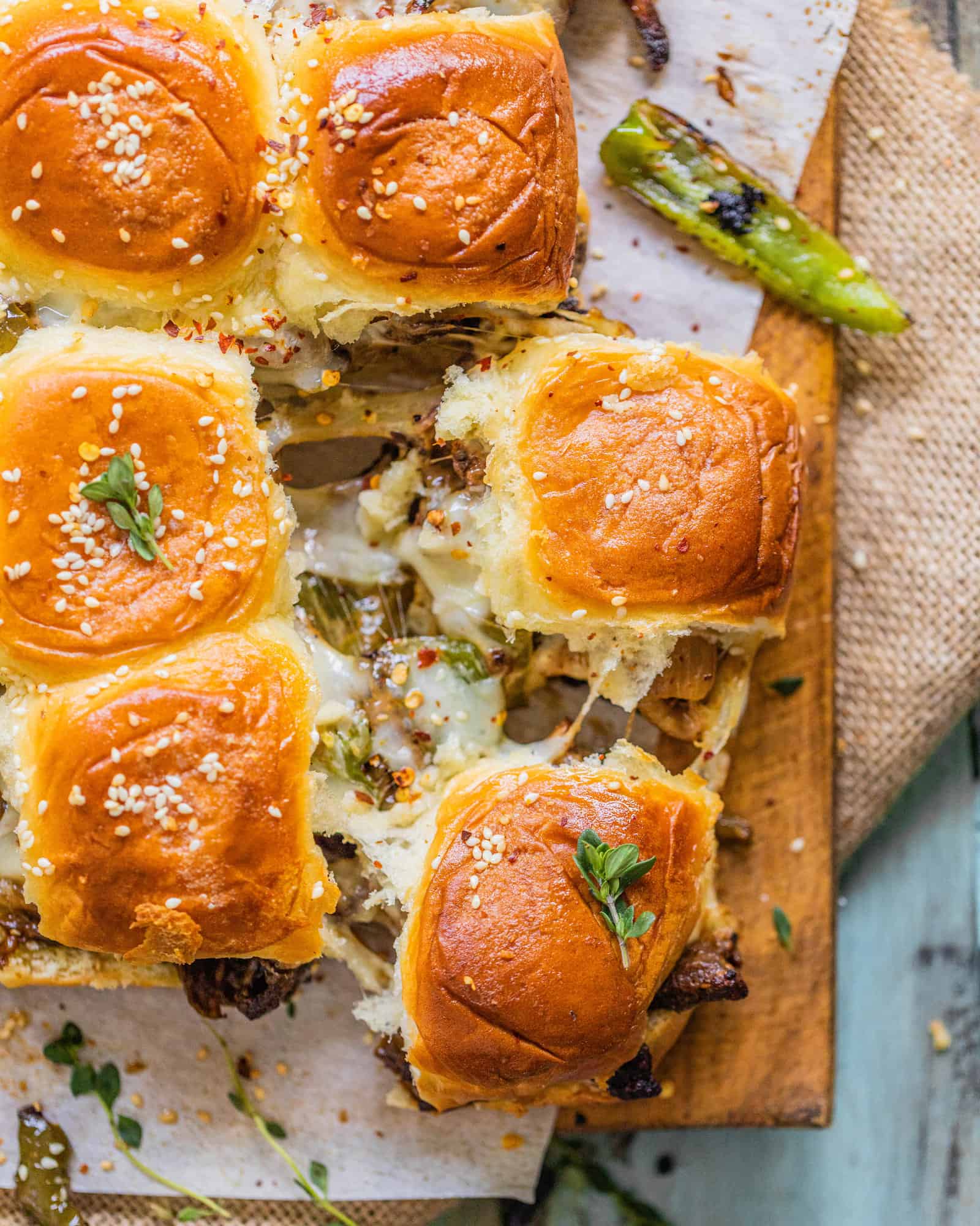 two philly cheesesteak sliders with green peppers and cheese