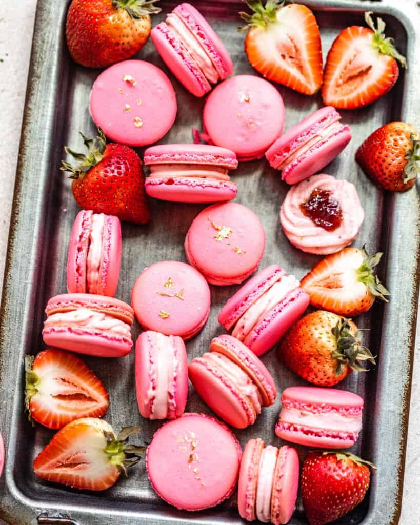 large tray of macarons with strawberries