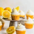 lemon drizzle cupcakes on a small cake stand garnished with sliced lemons