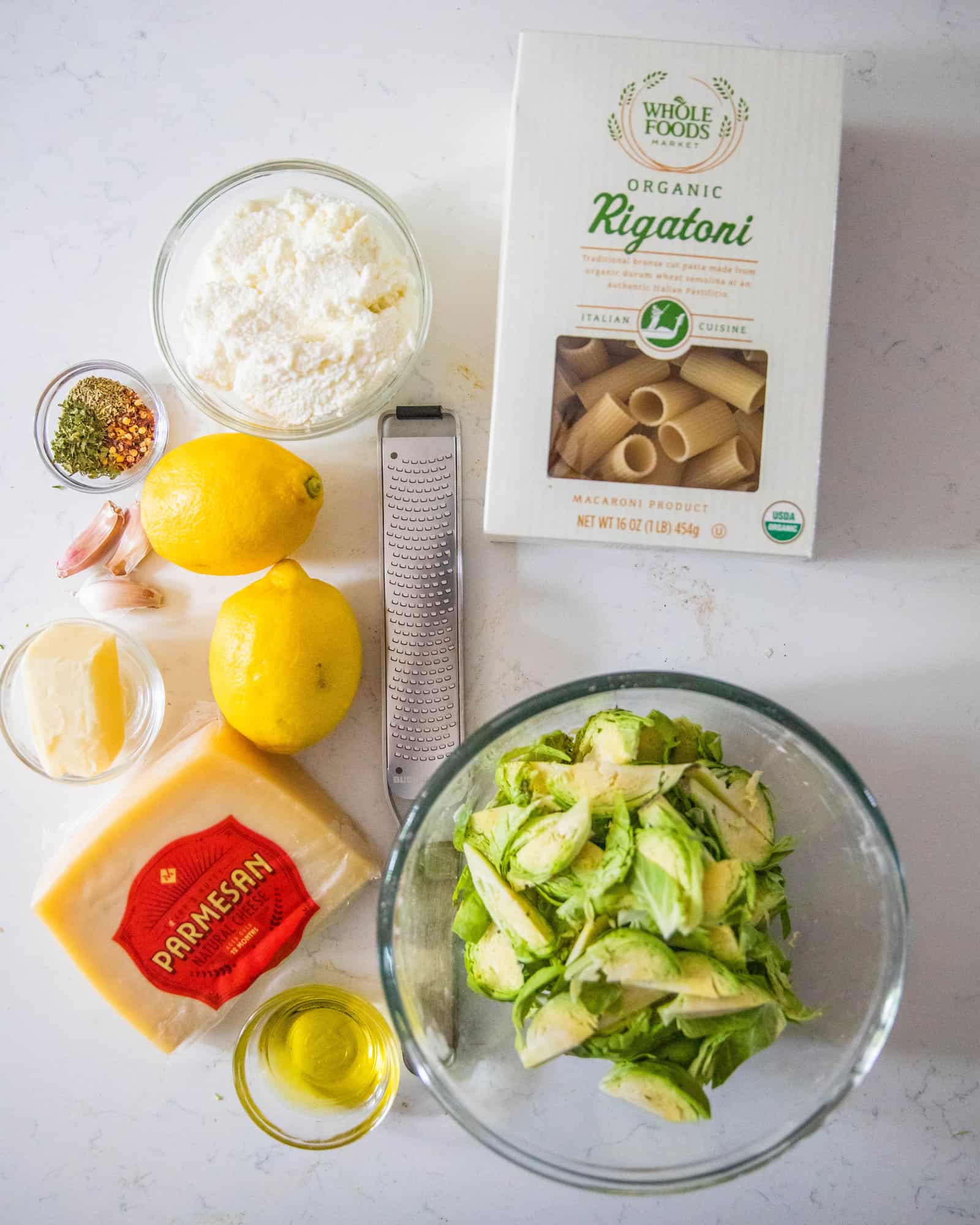 ingredients to make lemon ricotta pasta on a white table