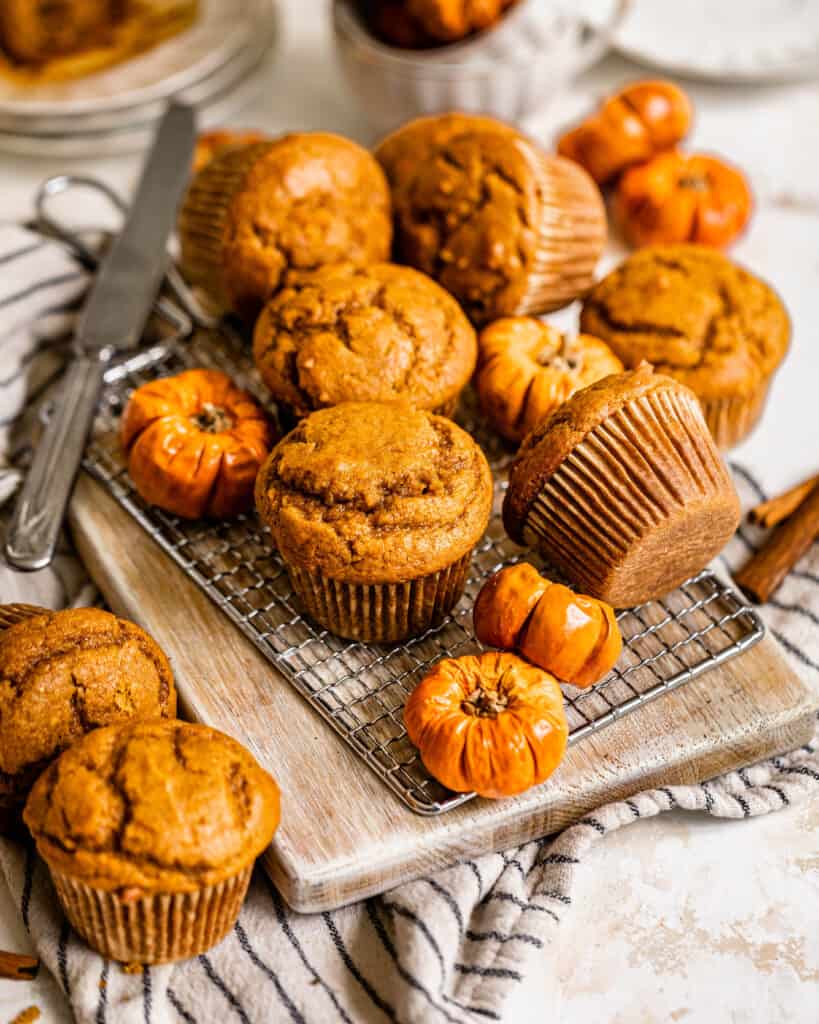 pumpkin muffins on a serving board with mini pumpkin