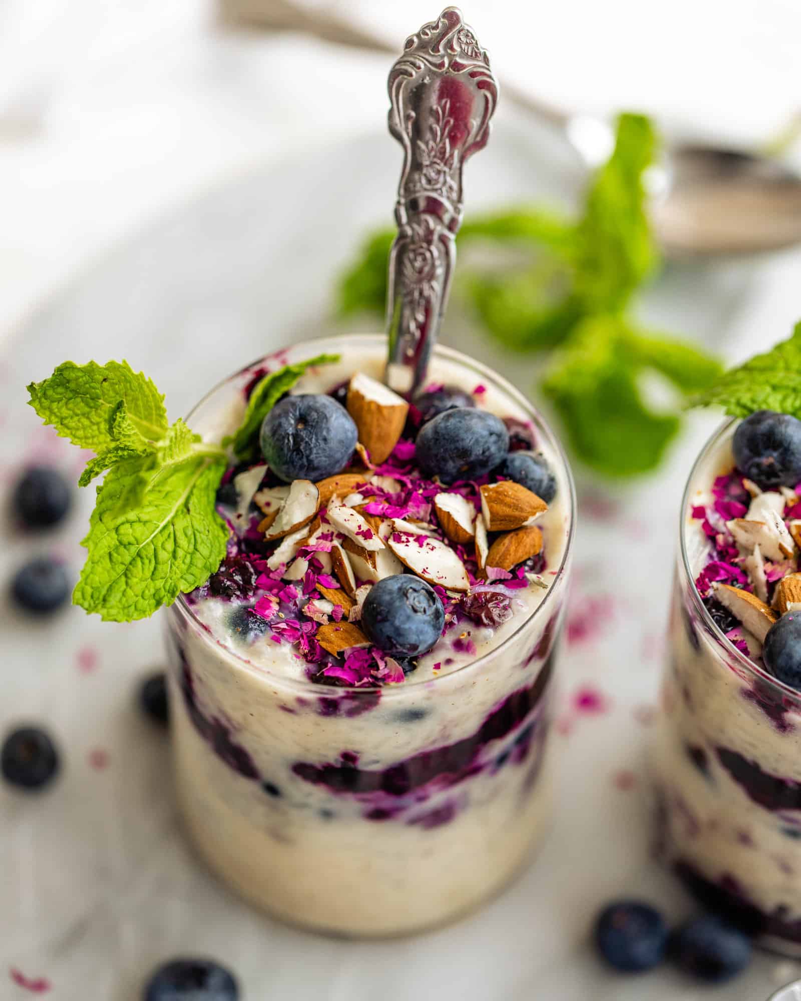 cups of rice pudding with almonds and blueberries on top