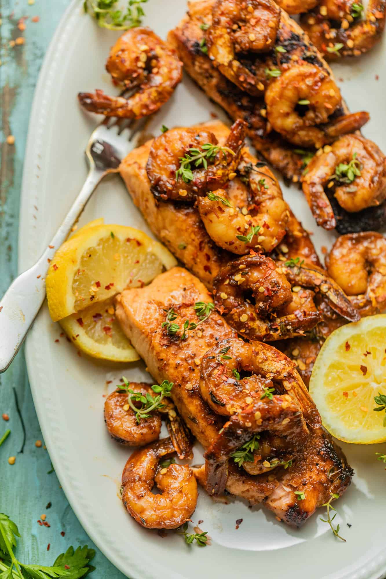 three salmon filets on a plate with lemon and shrimp