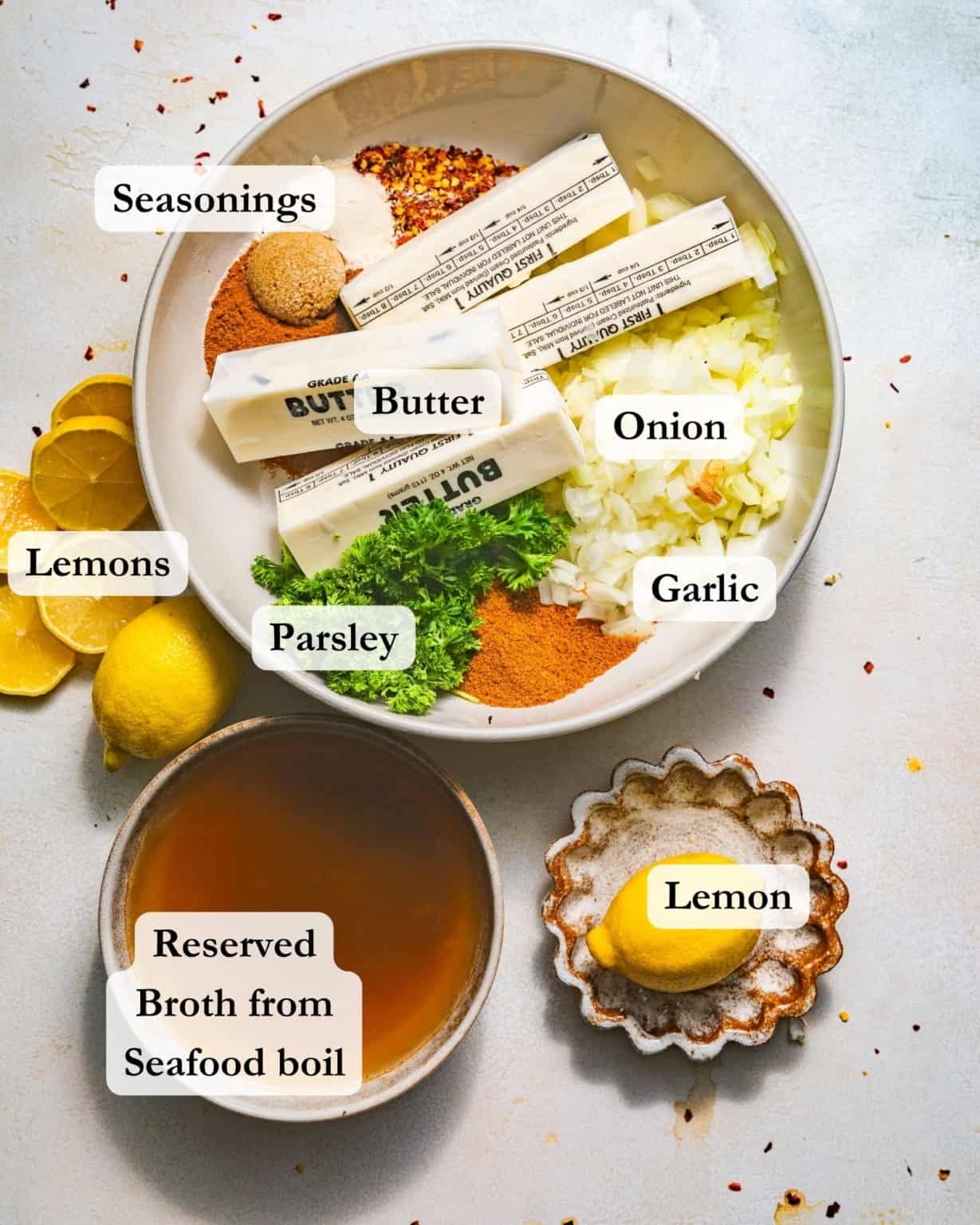 ingredients for garlic butter seafood boil sauce - butter, garlic, onion, lemon, seasonings, parsley, and broth.