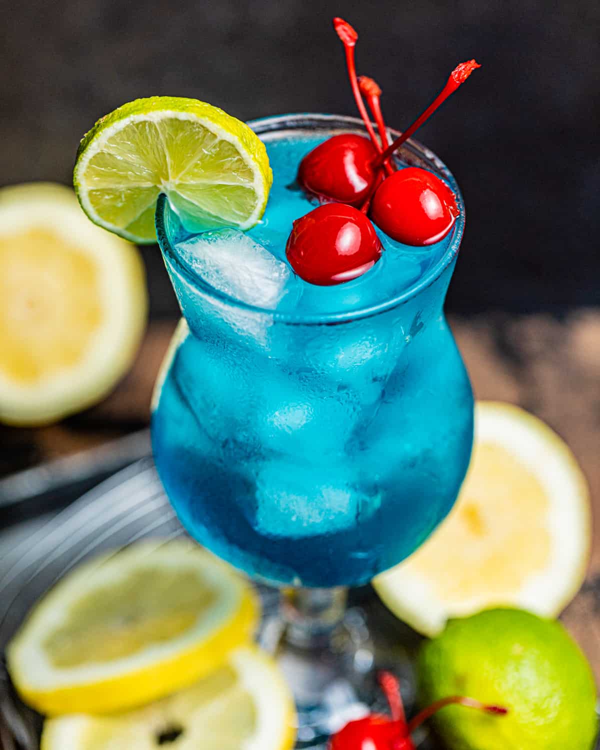 an up close photo of an AMF drink garnished with cherries and a lime wedge.